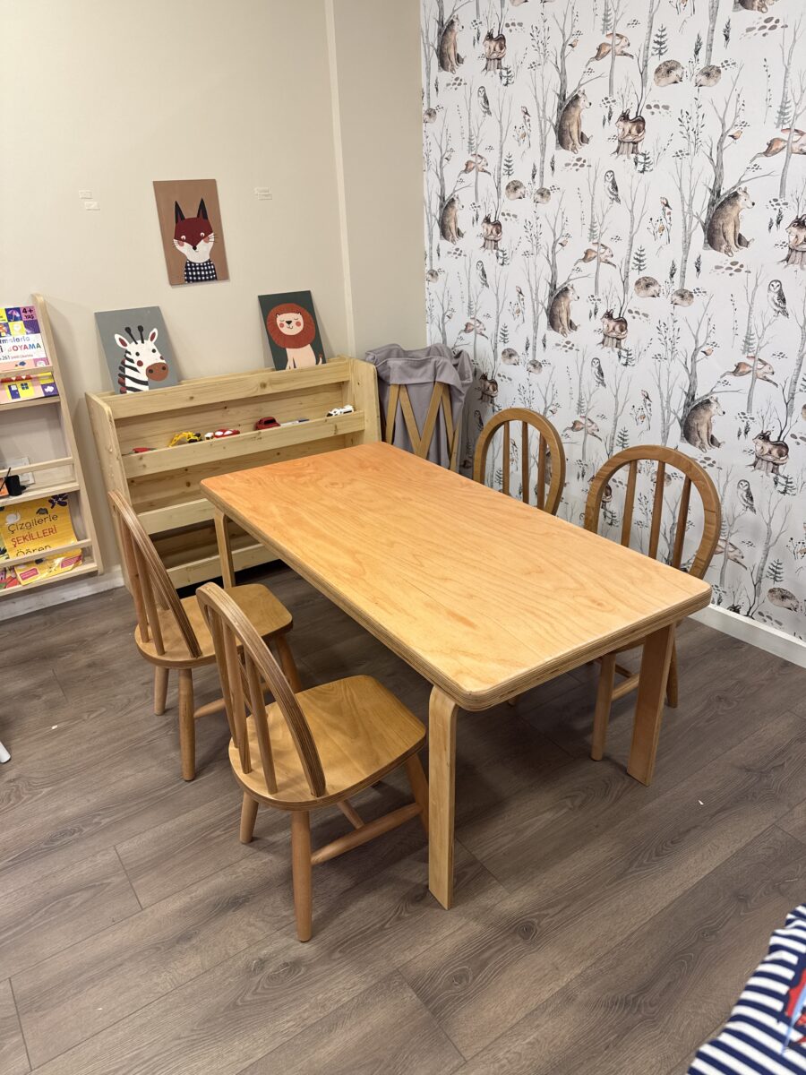 Alt Metin: Kayın kontraplak masa 120x60 cm amerikan sandalye seti anaokulu sınıf ortamı - Lilikids Shop Başlık: Kayın Kontraplak Masa Amerikan Sandalye Seti | Lilikids Shop Açıklama: Kayın kontraplak masa 120x60 cm ve Windsor sırtlı amerikan sandalye seti. Anaokulu sınıf ortamında, arka planda ahşap kitaplık ve orman desenli duvar. 2-6 yaş. Altyazı: Lilikids kayın kontraplak masa ve amerikan sandalye seti — anaokulu sınıf ortamı Dosya Adı: kayin-kontraplak-masa-120x60-amerikan-sandalye-anaokulu-lilikids.jpg